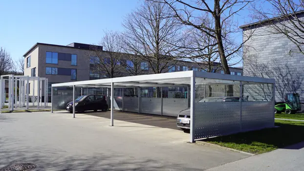 UNA-Carport-System mit einer Verkleidung aus Lochblechplatten und Glas