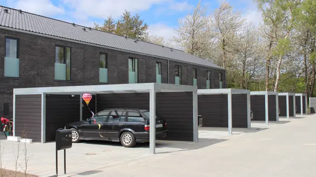 UNA-Carports in einer Reihe. Die Verkleidung zum Nachbarn ist eine Brandschutzwand