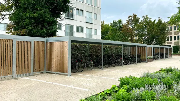 UNA-Fahrradüberdachung mit Seitenverkleidung aus Lamellen und Sedumdach